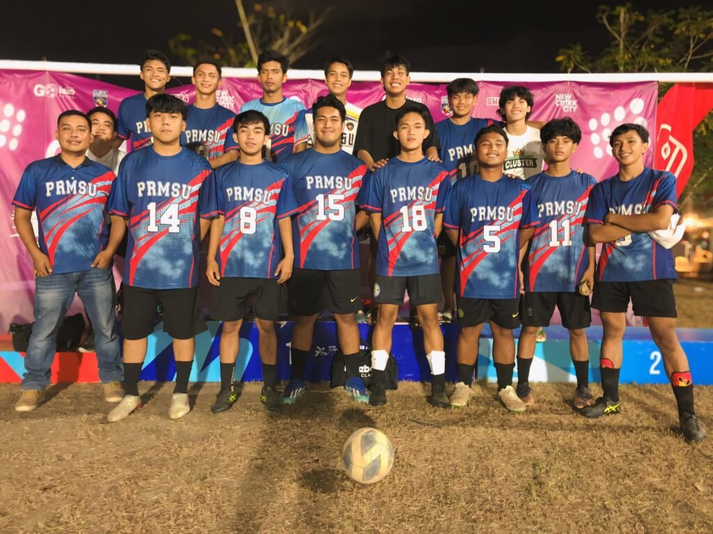 PRMSU football team group photo in blue and red jerseys during a tournament, representing President Ramon Magsaysay State University with pride and teamwork.