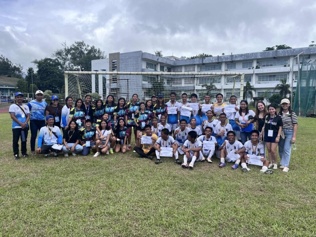 Milagros United Football Club players and coaches posing with certificates and medals on the football field in Masbate.
