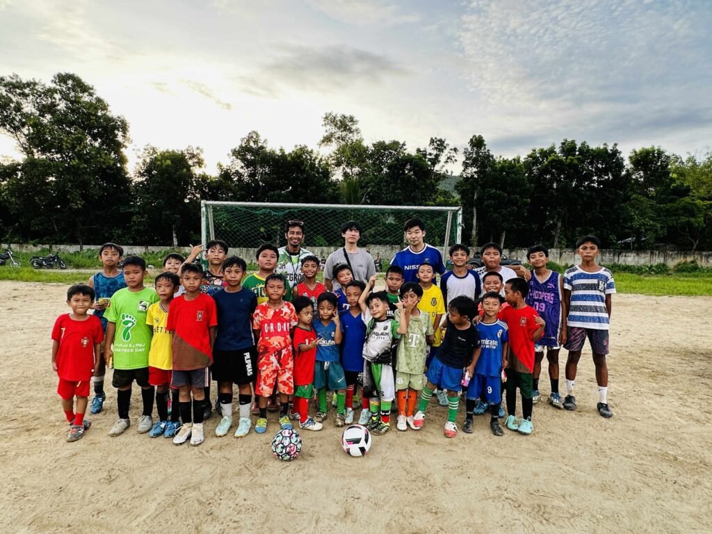Ajuy Paglaum Football Club youth players pose after training on a rural football field in Ajuy, Iloilo, showing teamwork and passion for the sport.