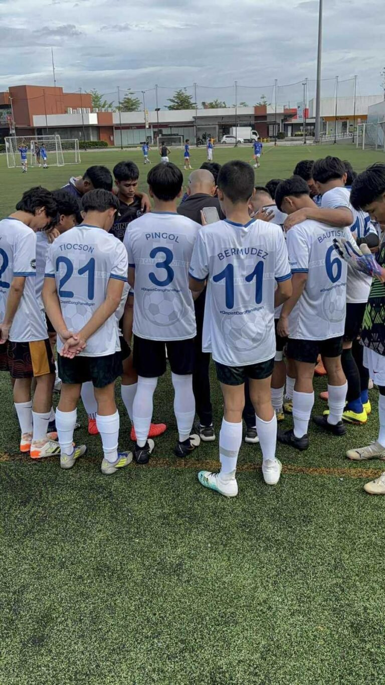 LCFC players in prayer huddle before a football match in Calapan City, promoting teamwork, faith, and unity.