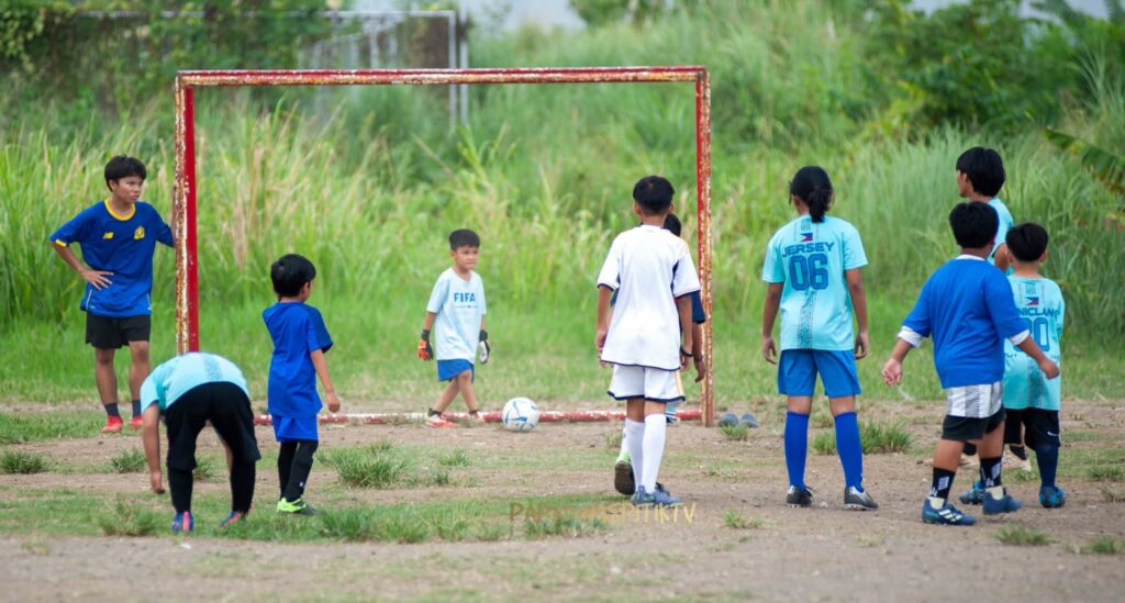 Young children playing grassroots football during a community training session in the Philippines