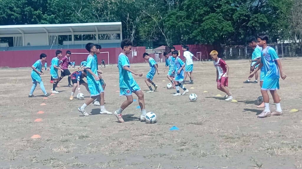 Youth players of Sta. Mesa Football Club participate in football dribbling drills during a grassroots training session at PUP Sta. Mesa Football Field in Manila.