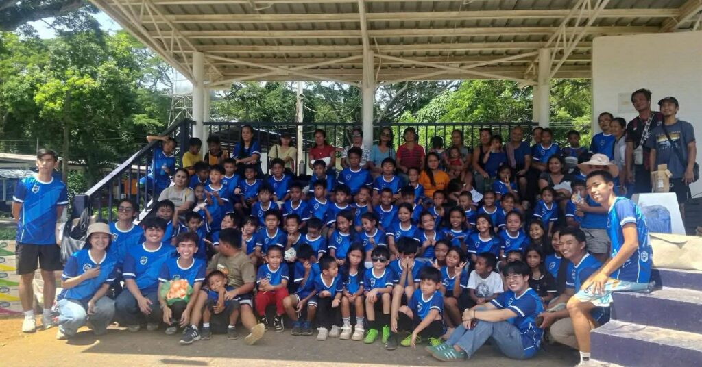 Young participants of the Kick It Futsal Summer Clinic posing with medals after completing a grassroots futsal training program in Puerto Princesa City, Palawan